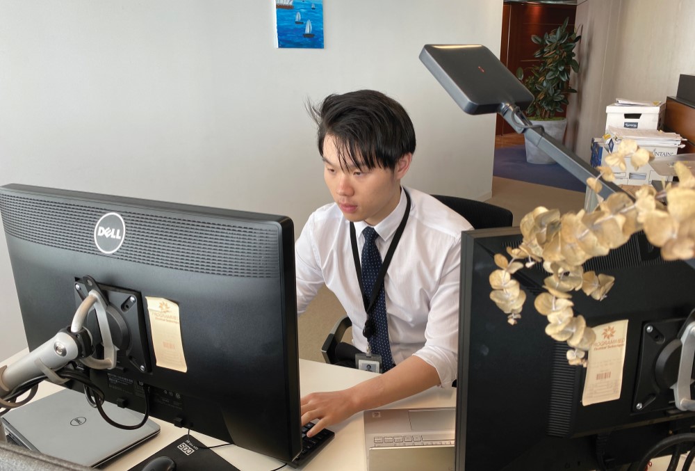 Male graduate sitting on his desk